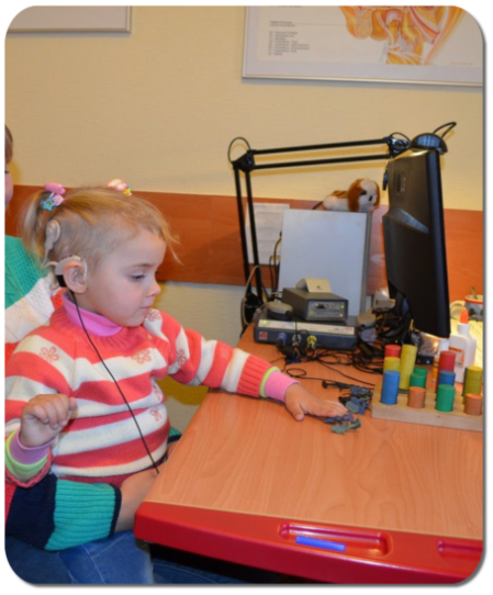 Kind Cochlea Implantat bei Audiologe 